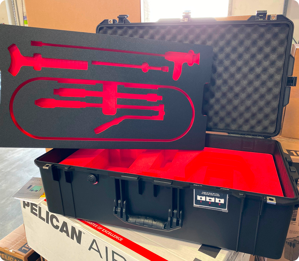 Custom foam insert with precision-cut red and black XLPE foam fitted inside a black Pelican Air case for gear protection