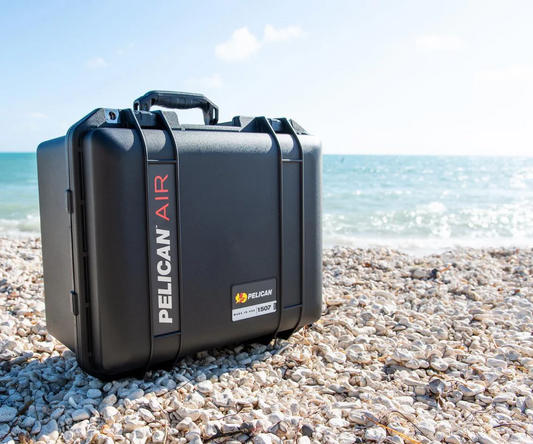 Pelican Air travel case placed on a rocky beach, showcasing lightweight build and rugged protection for air and field travel.