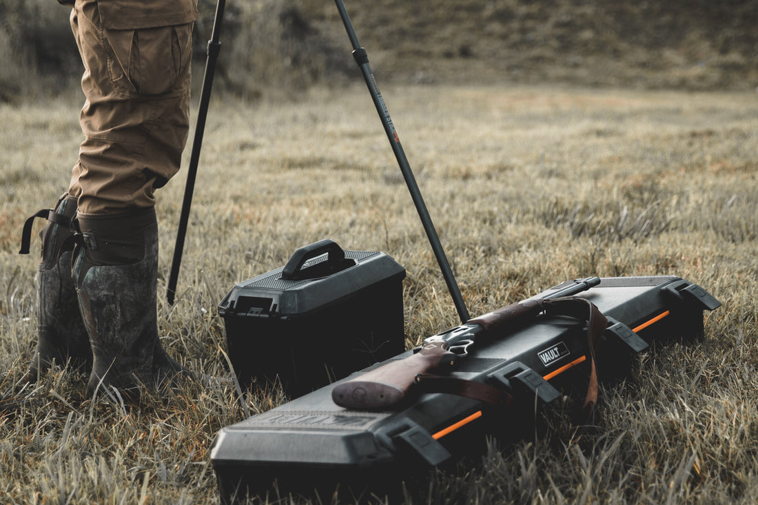 Professional camera setup in the wild showing a rugged photography hard case and a tactical gun case for outdoor protection.